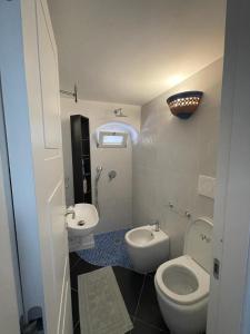 a small bathroom with a toilet and a sink at Arabesque in Lacco Ameno +13 photos