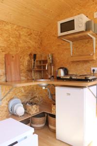 una pequeña cocina con encimera y microondas en La Roulotte Viticole - sauna - toilette sèche, en Floreffe
