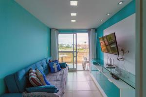 uma sala de estar com paredes azuis e um sofá azul em Porto Plaza #402 - Flat espaçoso por Carpediem em Porto de Galinhas