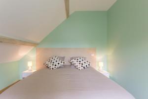 une chambre avec un grand lit et deux oreillers dans l'établissement Maison Baduel, à Auxey-Duresses