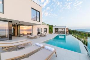 a house with a swimming pool and a patio at Villa rOvni in Labin