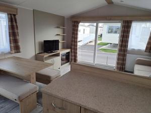 ein Wohnzimmer mit einem Tisch und einem großen Fenster in der Unterkunft Edwards Holiday Home in Blackpool