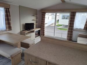 a living room with a table and a large window at Edwards Holiday Home in Blackpool