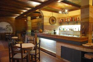 a restaurant with a bar with tables and chairs at Firenze Apartments in Ulcinj