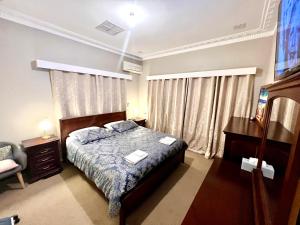 a bedroom with a bed with two towels on it at Bõucher Manor - Northam in Northam