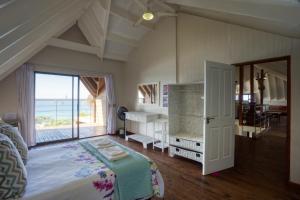a bedroom with a bed and a view of the ocean at Mar Azul 18 in Ponta Malangane