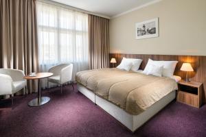 a hotel room with a bed and a table and chairs at Clarion Hotel Prague Old Town in Prague