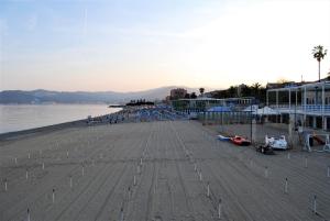 a beach with a pier and buildings and the water at Casa D'Aria in Savona