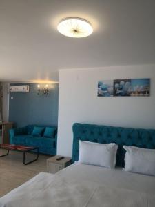 a bedroom with a bed and a blue couch at Hotel La John in Vama Veche