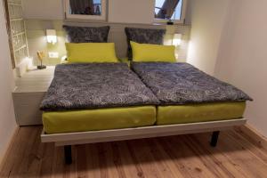 a bed in a room with yellow pillows on it at Hinterm Marstall 2 in Coburg