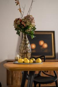a vase with flowers and lemons on a table at Hinterm Marstall 2 in Coburg