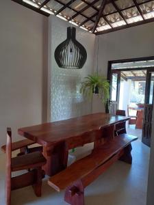 una mesa de madera y bancos en una habitación en Uma Casa para o Descanso!, en Camaçari