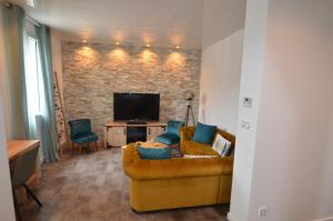 Una sala de estar con un sofá y un televisor. en Maison Bon Air Capbreton, en Capbreton