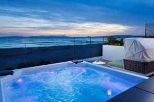 a hot tub with a view of the ocean at The Sense Experience Resort in Follonica