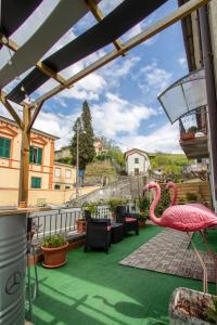 a patio with a large pink flamingo on a balcony at MAISON44 in Carrodano Inferiore
