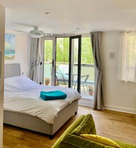 1 dormitorio con 1 cama y balcón en Gorgeous Central Studio with Balcony, 2 mins to Beach and Pier, en Worthing