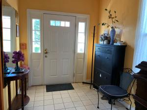 a room with a door and a chair and a table at Beautiful Victorian house, Room in Boston