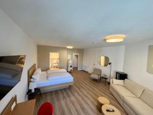 Habitación de hotel con cama y sofá en Hotel Spiegel Garni, en Lindau