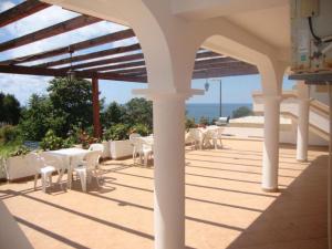 a patio with white tables and chairs and the ocean at Firenze Apartments in Ulcinj +25 photos
