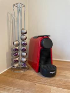 a red and black appliance next to a rack of onions at Vakantiehuis Zeevonk Koudekerke in Koudekerke +9 photos