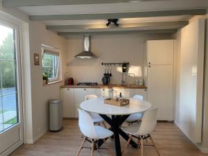 een keuken en eetkamer met een tafel en stoelen bij Vakantiehuis Zeevonk Koudekerke in Koudekerke