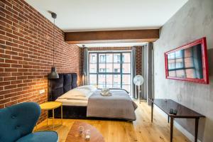 a bedroom with a bed and a brick wall at City Lights Kazimierz in Krakow