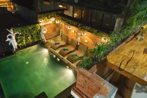 uma vista superior para uma piscina com uma mesa de madeira em Ubudku Villas em Ubud