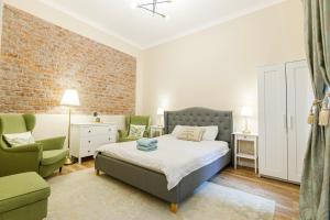 a bedroom with a bed and a couch and a chair at Beautiful Apartment in Heart of Historical Center in Timişoara