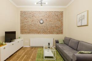 a living room with a couch and a brick wall at Beautiful Apartment in Heart of Historical Center in Timişoara