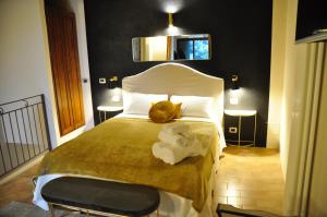 1 dormitorio con 1 cama con toallas en suite la fortezza, en Montalcino