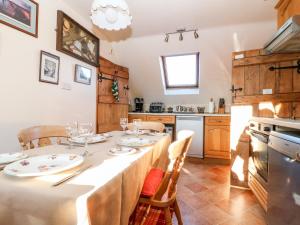 a dining room with a table and a kitchen at Magnolia Apartment in Bourton on the Water