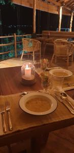 a table with a plate of soup and a candle at Oruwa Boutique Villas in Arugam Bay