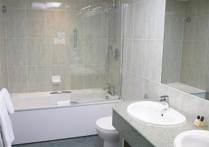 a bathroom with a tub and a toilet and a sink at Sandbanks Hotel in Poole