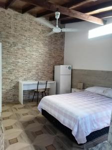 a bedroom with a bed and a table and a refrigerator at Granados in Asuncion