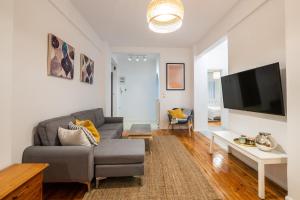 uma sala de estar com um sofá e uma televisão de ecrã plano em Ikos central spacious apartment em Tessalônica