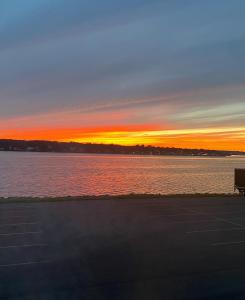 a sunset over the water with a parking lot at Harbourview Inn and Suites in Sydney