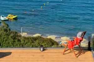 a plastic chair sitting on a ledge next to the ocean at Beachfront Villa Phi φ in Agios Nikolaos