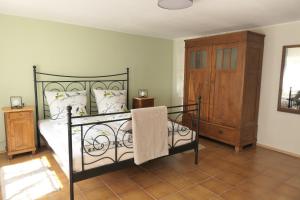 1 dormitorio con cama negra y armario de madera en Ferienwohnung im Brohlbachtal, en Kaifenheim