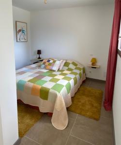 een slaapkamer met een bed en twee tapijten bij Les Chêneslierres in Lourmarin