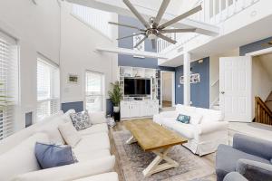 a living room with white furniture and a ceiling fan at BayWalk by Meyer Vacation Rentals in Fort Morgan