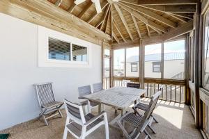 a dining room with a table and chairs on a balcony at BayWalk by Meyer Vacation Rentals in Fort Morgan