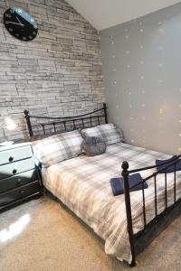 1 dormitorio con cama y pared de ladrillo en Stylish ground floor conversion near Bath and Priston with outstanding views en Priston