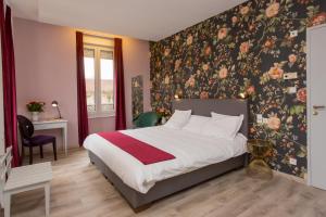 - une chambre avec un lit et un papier peint floral dans l'établissement Hôtel d'Angleterre (by Popinns), à Vittel