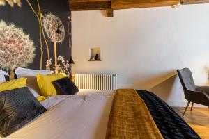 um quarto com uma cama com almofadas amarelas e pretas em Les Vendangettes em Gevrey-Chambertin