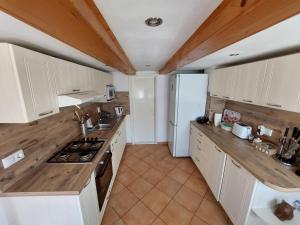 a kitchen with white cabinets and a white refrigerator at Hajni Vendégház in Kisapáti