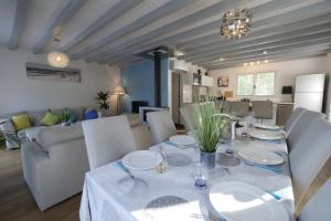 a dining room with a table with white plates on it at Villa avec piscine pour 8 in Saint-Jean-de-Monts