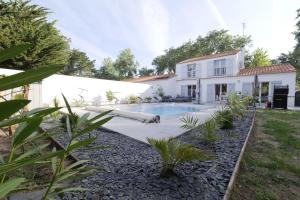 a house with a swimming pool in the yard at Villa avec piscine pour 8 in Saint-Jean-de-Monts