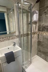 La salle de bains est pourvue d'une douche et d'un lavabo. dans l'établissement Stylish ground floor conversion near Bath and Priston with outstanding views, à Priston