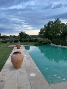 een zwembad met twee grote vazen ernaast bij Mas Generós - Adults-Only Eco Hotel in Fonteta