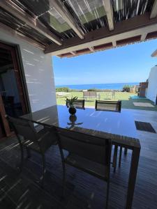 a dining room table with a view of the ocean at La Costa Est Villa con Vista Mare in Ogliastra Sardegna in Tertenìa